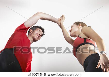 Stock Photograph - Couple in running gear high fiving. Fotosearch