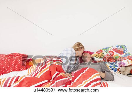 Couple kissing in bed View Large Photo Image Stock Photo - Couple kissing in bed. Fotosearch