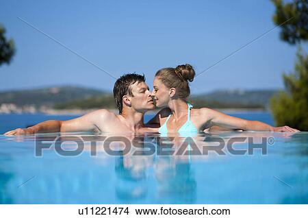 Couple kissing in infinity pool View Large Photo Image Picture - Couple kissing in infinity pool. Fotosearch