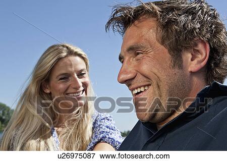 Couple laughing together outdoors View Large Photo Image Stock Photo - Couple laughing together outdoors. Fotosearch