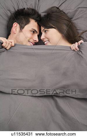 Couple laying in bed together View Large Photo Image Stock Image - Couple laying in bed together. Fotosearch