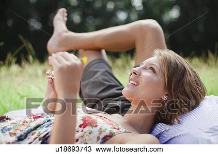 Couple laying in field together View Large Photo Image Stock Image - Couple laying in field together. Fotosearch