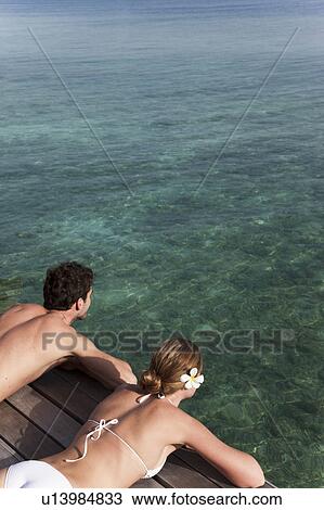 Couple laying on deck overlooking sea View Large Photo Image Stock Image - Couple laying on deck overlooking sea. Fotosearch