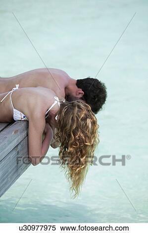 Couple laying on deck overlooking water View Large Photo Image Stock Photography - Couple laying on deck overlooking water. Fotosearch