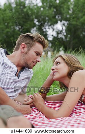 Stock Photo - Couple laying on picnic blanket. Fotosearch