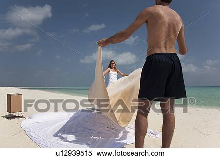 Couple making bed on beach View Large Photo Image Stock Photography - Couple making bed on beach. Fotosearch
