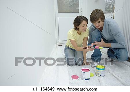 Stock Photo - Couple painting together in new home. Fotosearch