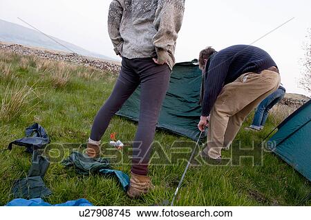 Couple pitching a tent at campsite View Large Photo Image Stock Photography - Couple pitching a tent at campsite. Fotosearch