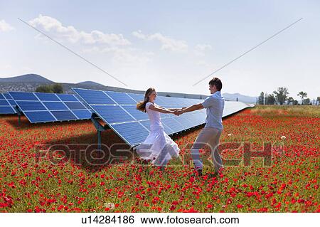 Stock Photograph - Couple playing by solar panels. Fotosearch