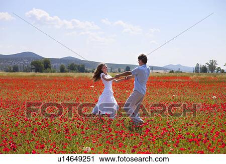 Couple playing in field of poppies View Large Photo Image Stock Image - Couple playing in field of poppies. Fotosearch