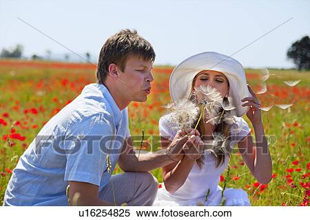 Stock Photography - Couple playing in field of poppies. Fotosearch