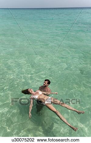Couple playing in tropical sea View Large Photo Image Stock Image - Couple playing in tropical sea. Fotosearch