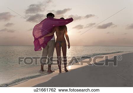 Couple playing on beach at sunset View Large Photo Image Stock Image - Couple playing on beach at sunset. Fotosearch