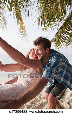 Couple playing on swing at beach View Large Photo Image Stock Image - Couple playing on swing at beach. Fotosearch