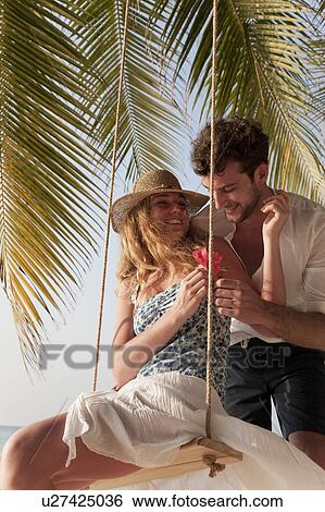 Couple playing on swing View Large Photo Image Stock Photograph - Couple playing on swing. Fotosearch