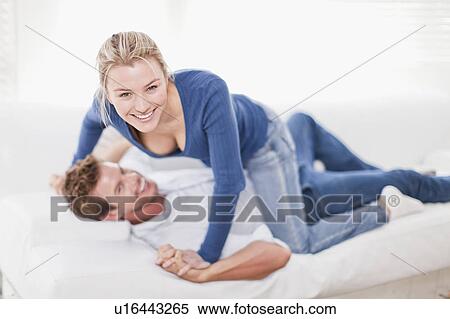 Couple playing together on couch View Large Photo Image Stock Photography - Couple playing together on couch. Fotosearch