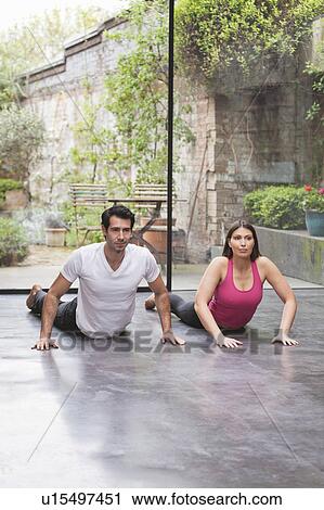 Couple practicing yoga together at home View Large Photo Image Stock Image - Couple practicing yoga together at home. Fotosearch