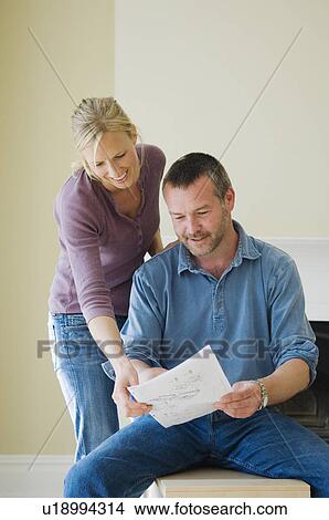 Couple reading instructions in new home View Large Photo Image Picture - Couple reading instructions in new home. Fotosearch