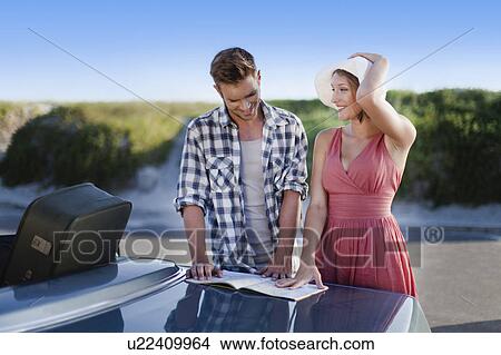 Picture - Couple reading map on roadside. Fotosearch