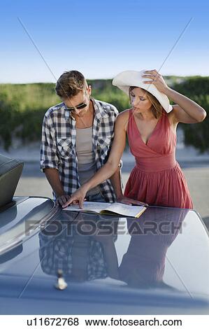 Couple reading map on roadside View Large Photo Image Stock Photo - Couple reading map on roadside. Fotosearch