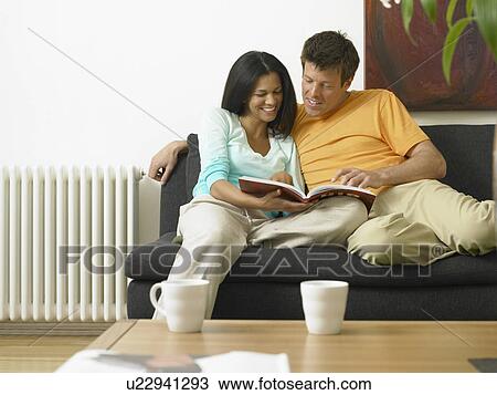 Couple reading on couch together View Large Photo Image Stock Image - Couple reading on couch together. Fotosearch