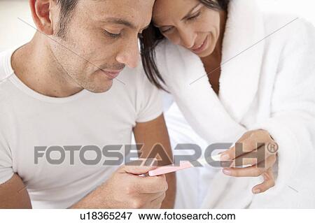 Stock Photo - Couple reading pregnancy test together. Fotosearch