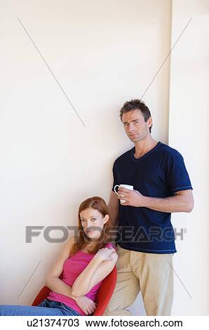 Stock Image - Couple relaxing at home together. Fotosearch