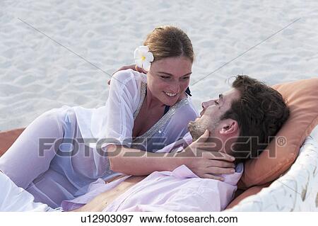 Stock Photo - Couple relaxing on beach. Fotosearch