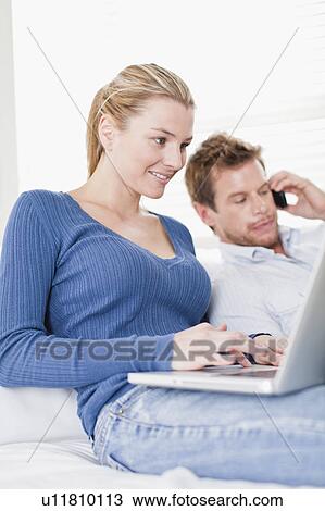 Stock Image - Couple relaxing on couch together. Fotosearch