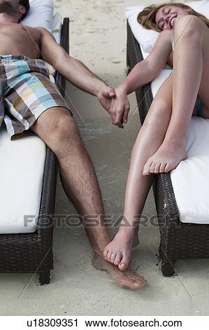Couple relaxing on daybeds at beach View Large Photo Image Stock Image - Couple relaxing on daybeds at beach. Fotosearch