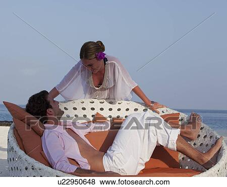 Couple relaxing on tropical beach View Large Photo Image Stock Photo - Couple relaxing on tropical beach. Fotosearch