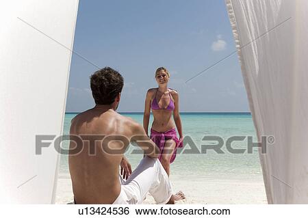 Couple relaxing on tropical beach View Large Photo Image Stock Photograph - Couple relaxing on tropical beach. Fotosearch