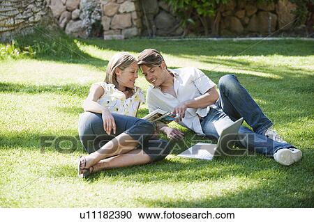 Couple relaxing together in grass View Large Photo Image Stock Image - Couple relaxing together in grass. Fotosearch
