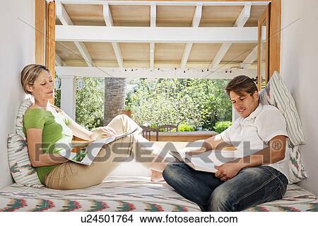 Couple relaxing together in nook View Large Photo Image Picture - Couple relaxing together in nook. Fotosearch