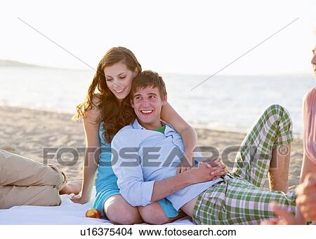 Couple relaxing together on beach View Large Photo Image Picture - Couple relaxing together on beach. Fotosearch