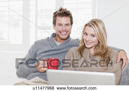 Stock Photo - Couple relaxing together on couch. Fotosearch