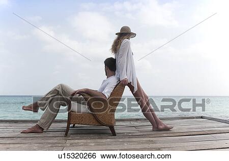 Couple relaxing together on deck View Large Photo Image Stock Photograph - Couple relaxing together on deck . Fotosearch