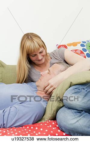 Stock Photo - Couple relaxing together on sofa. Fotosearch