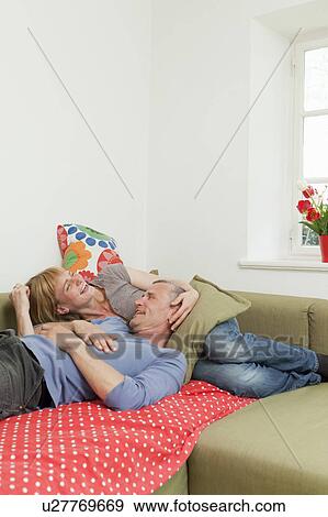 Couple relaxing together on sofa View Large Photo Image Stock Photo - Couple relaxing together on sofa. Fotosearch