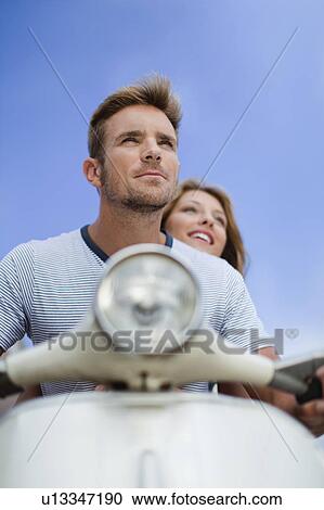 Couple riding scooter together View Large Photo Image Stock Image - Couple riding scooter together. Fotosearch