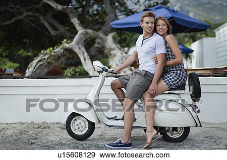 Couple riding scooter together View Large Photo Image Stock Photo - Couple riding scooter together. Fotosearch