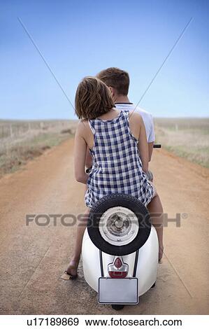 Stock Photo - Couple riding scooter together. Fotosearch