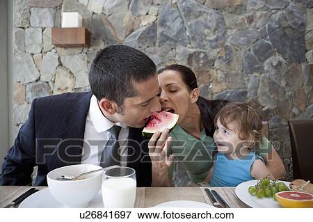 Stock Photo - Couple sharing watermelon at breakfast. Fotosearch