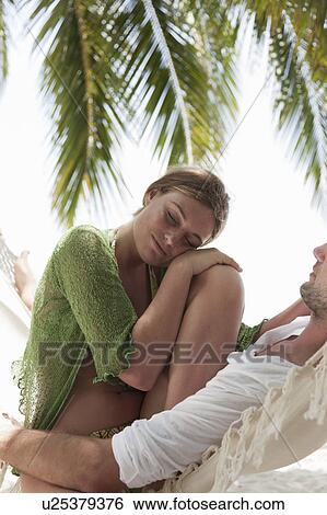 Couple sitting in hammock on beach View Large Photo Image Stock Photograph - Couple sitting in hammock on beach. Fotosearch