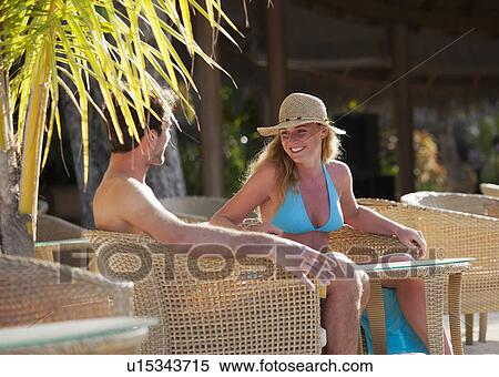 Stock Photography - Couple sitting in wicker chairs outdoors. Fotosearch