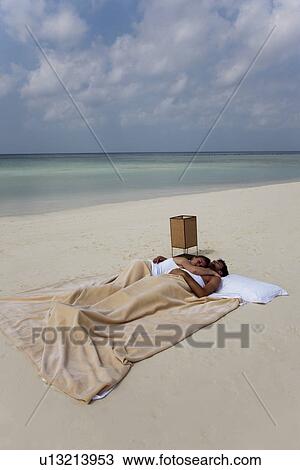 Couple sleeping in bed on beach View Large Photo Image Stock Image - Couple sleeping in bed on beach. Fotosearch