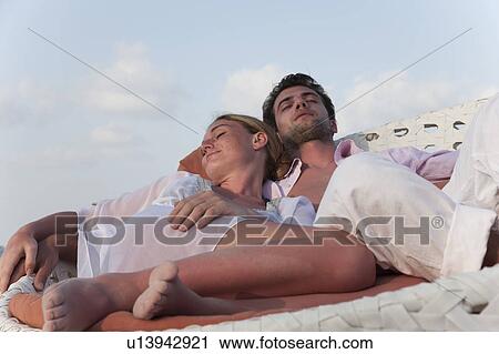 Couple sleeping in wicker chair View Large Photo Image Stock Image - Couple sleeping in wicker chair. Fotosearch