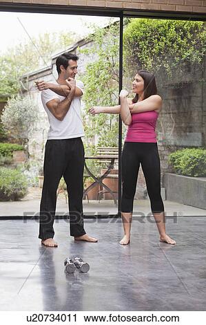 Stock Image - Couple stretching before exercise. Fotosearch