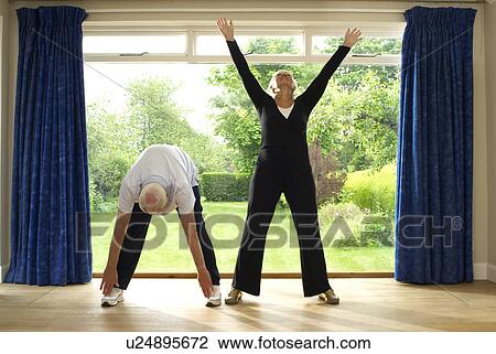 Stock Image - Couple stretching together indoors. Fotosearch