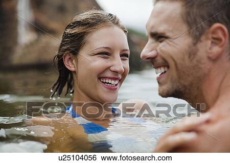 Stock Photograph - Couple swimming in lake together. Fotosearch